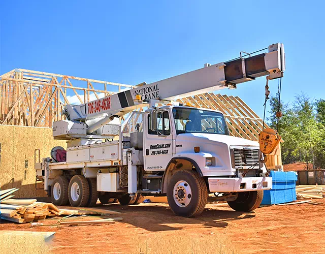 Photo of a crane truck parked at a building site