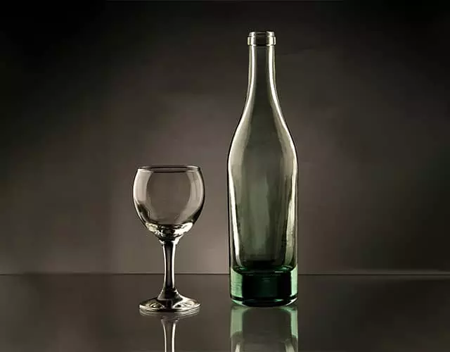 Glass bottle and wine glass on a dark backdrop before masking