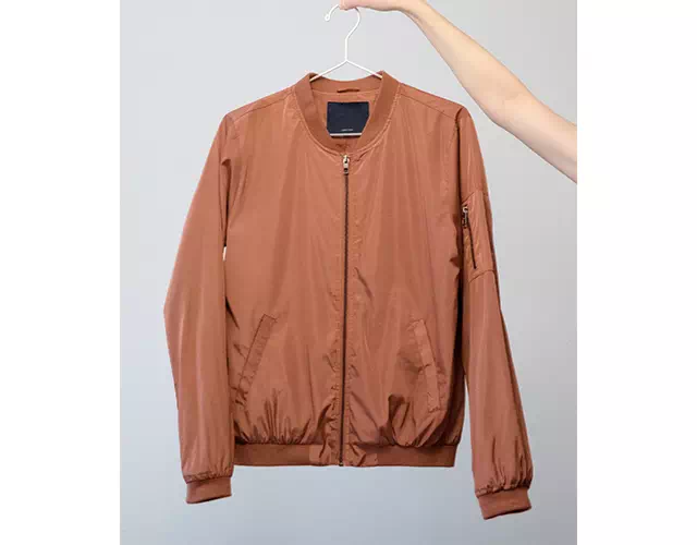 Bomber jacket held by a hand and clip before editing
